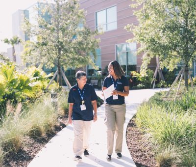 Two healthcare workers walking and talking Two healthcare workers walking and talking